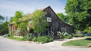 A rustic barn with a sign indicating it houses a gallery and art store.