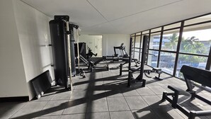A gym with various exercise equipment, large windows, and a tiled floor. - Mirante do Porto Vista Mar 304 byLP (Ipojuca)