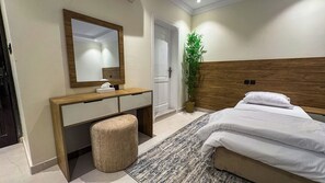 Comfort Room | Desk, laptop workspace, blackout drapes, iron/ironing board - Rewaq Resident (Madinah)