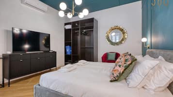 Une chambre moderne avec un grand lit, une télévision, une armoire et un miroir.