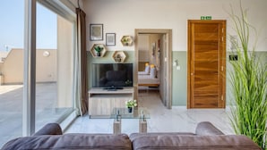 Un moderno vestíbulo de hotel con un área de descanso, un televisor y una planta.
