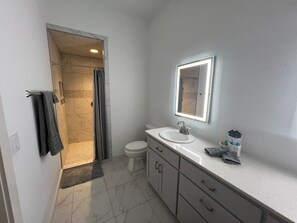 Un baño con ducha, inodoro y lavabo.