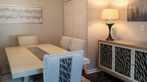 A dining area with a table, chairs, a lamp, and a cabinet. - SPOTLESS Geneva home!  MINUTES to Wineries, Spires, Downtown, & the Strip! (Geneva)