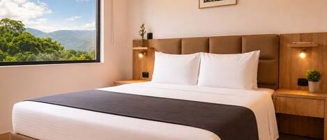 Una habitación de hotel moderna con una cama grande, vistas a zonas verdes y una obra de arte enmarcada en la pared.