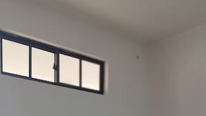A black sofa in a room with a tiled floor and a window with blinds. - Hotel Dorado Baq (Barranquilla)