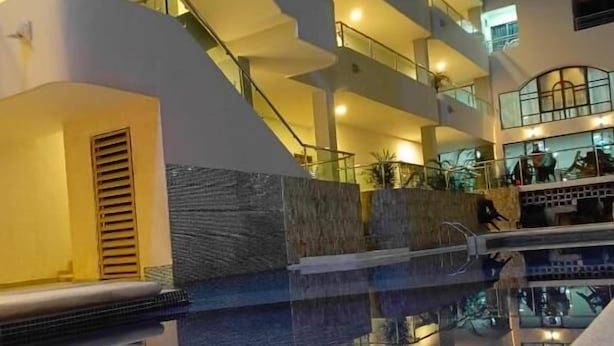 A multi-level hotel with a swimming pool, outdoor seating, and a staircase. - Hotel Dorado Baq (Barranquilla)
