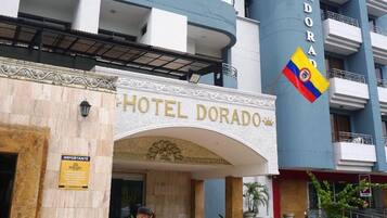 Exterior del Hotel Dorado, con una entrada destacada que incluye un arco decorativo y una bandera.