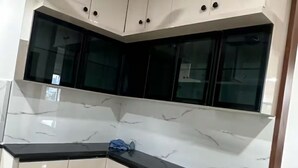 A kitchen with white cabinets, black countertops, and a ceiling fan. - Independent floor for rent in Hyderabad (Hayathnagar_Khalsa)