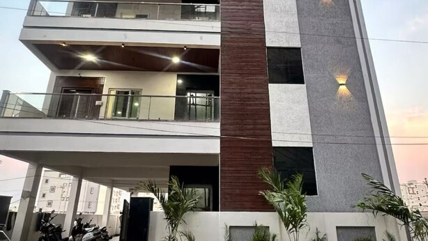 A modern multi-story building with a flat roof, large windows, and a central vertical element. - Independent floor for rent in Hyderabad (Hayathnagar_Khalsa)