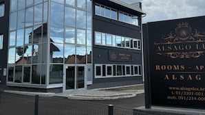 A modern building with a glass facade and a sign indicating it is a hotel named "Alsago Lux." - Alsago Lux (Sesvete)