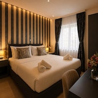 Habitación de hotel con una cama grande, dos mesitas de noche, un escritorio y una ventana con cortinas.