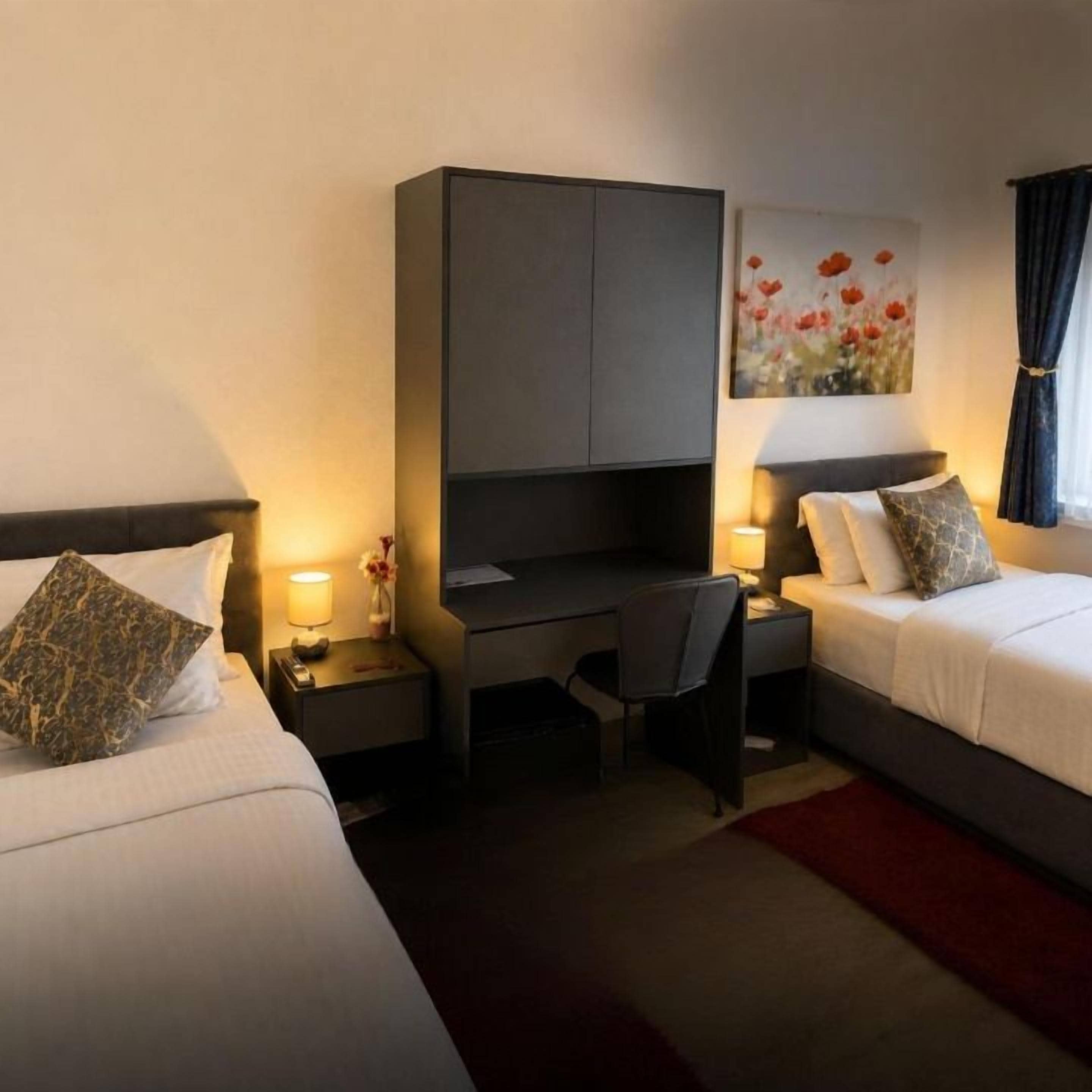 Una habitación de hotel con dos camas, un escritorio y una silla.
