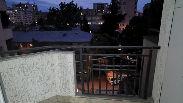 Un balcón con vista a un paisaje urbano al anochecer.