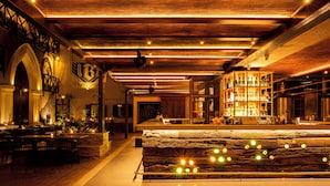 A bar area with a wooden bar counter, seating, and a large illuminated sign. - The Quarters Business Hotel (Bangalore)