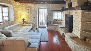 A cozy living room with a stone fireplace, a sofa, and a small table with a lamp. - Villa Annette with Pool - Istriensonne 0784 (Zminj)