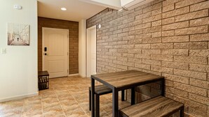 A room with a brick wall, a wooden table, and a tiled floor. - Clearlake Studio | Shared Pool + Boat Parking (Clearlake Oaks)