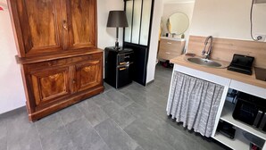A modern kitchen with a wooden cabinet, a black appliance, a sink, and a mirror. - Studio room with jacuzzi and heated swimming pool 4X8 (Alata)