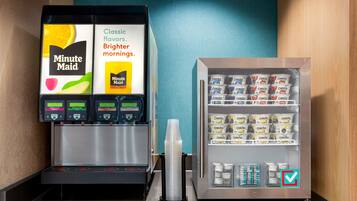 A coffee machine and a refrigerated display with various packaged goods.