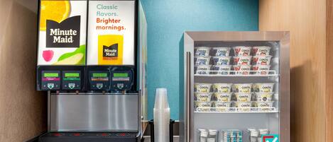 A coffee machine and a refrigerated display with various packaged goods.