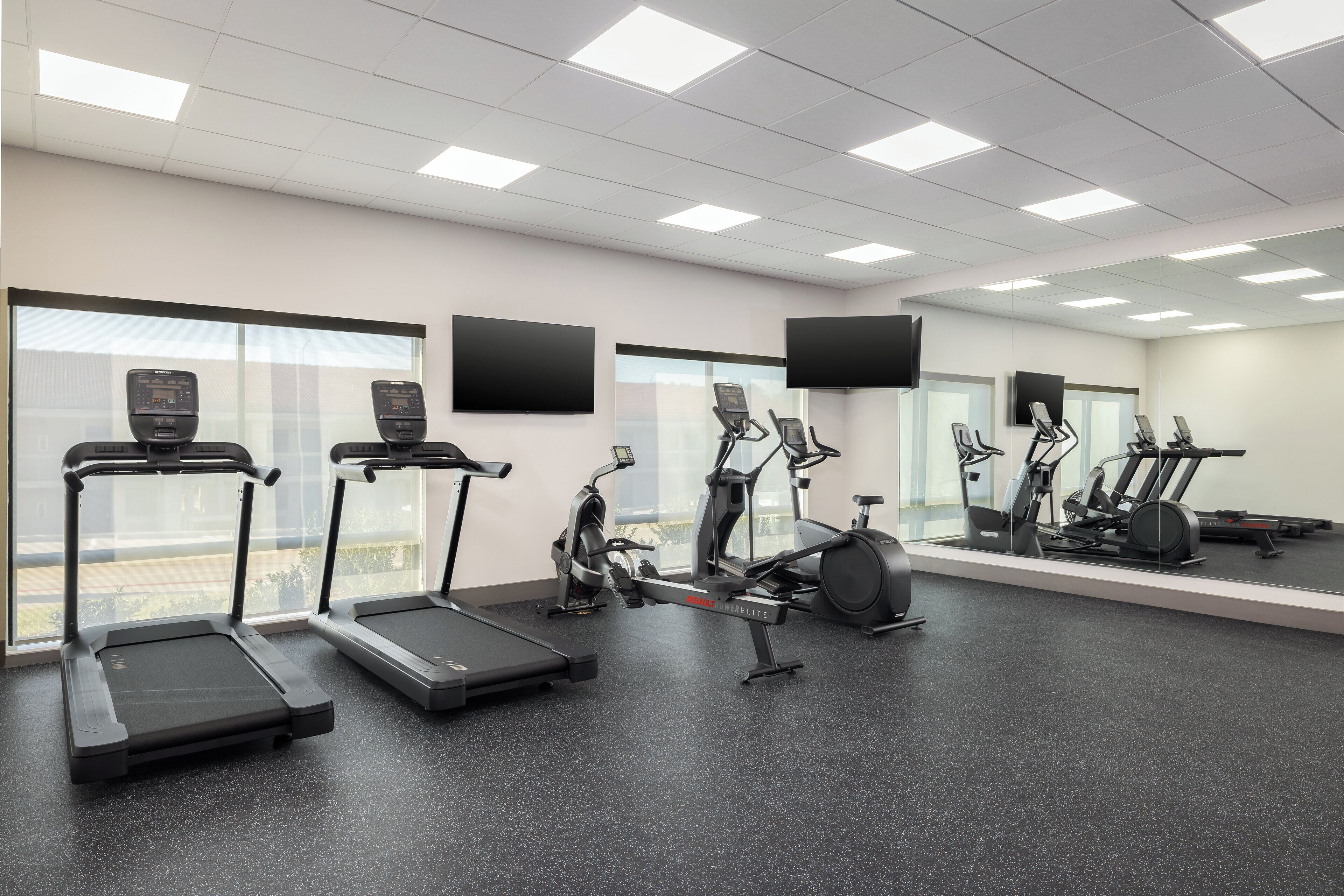 A gym with treadmills, elliptical machines, and stationary bikes.