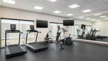 A gym with treadmills, elliptical machines, and stationary bikes.