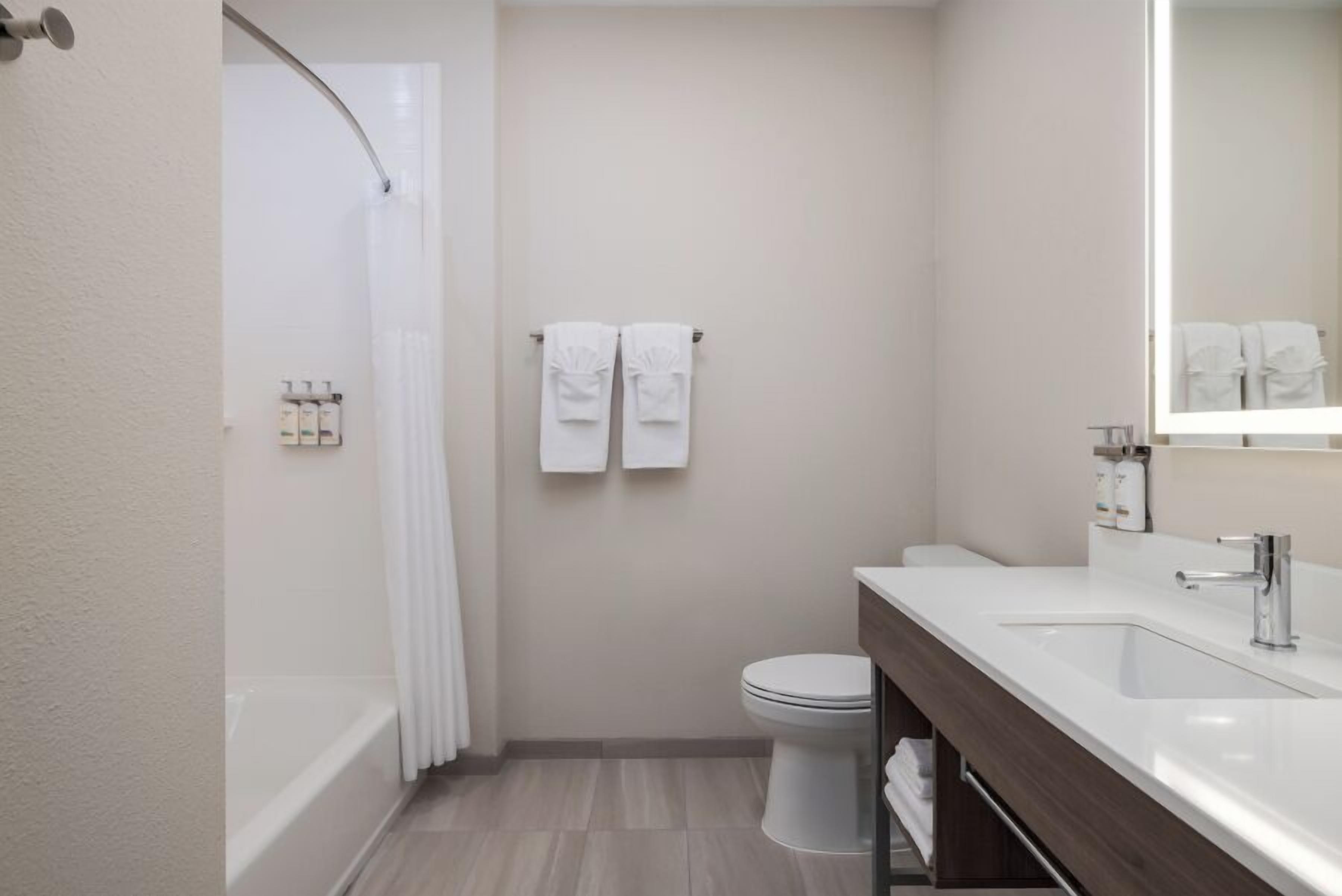 A modern bathroom with a bathtub, toilet, and sink.