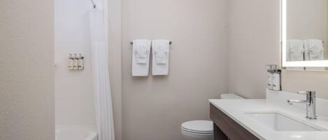 A modern bathroom with a bathtub, toilet, and sink.