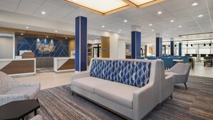 A modern lobby with a sofa, chairs, and a reception desk. - Holiday Inn Express And Suites Nacogdoches Southwest by IHG (Nacogdoches)