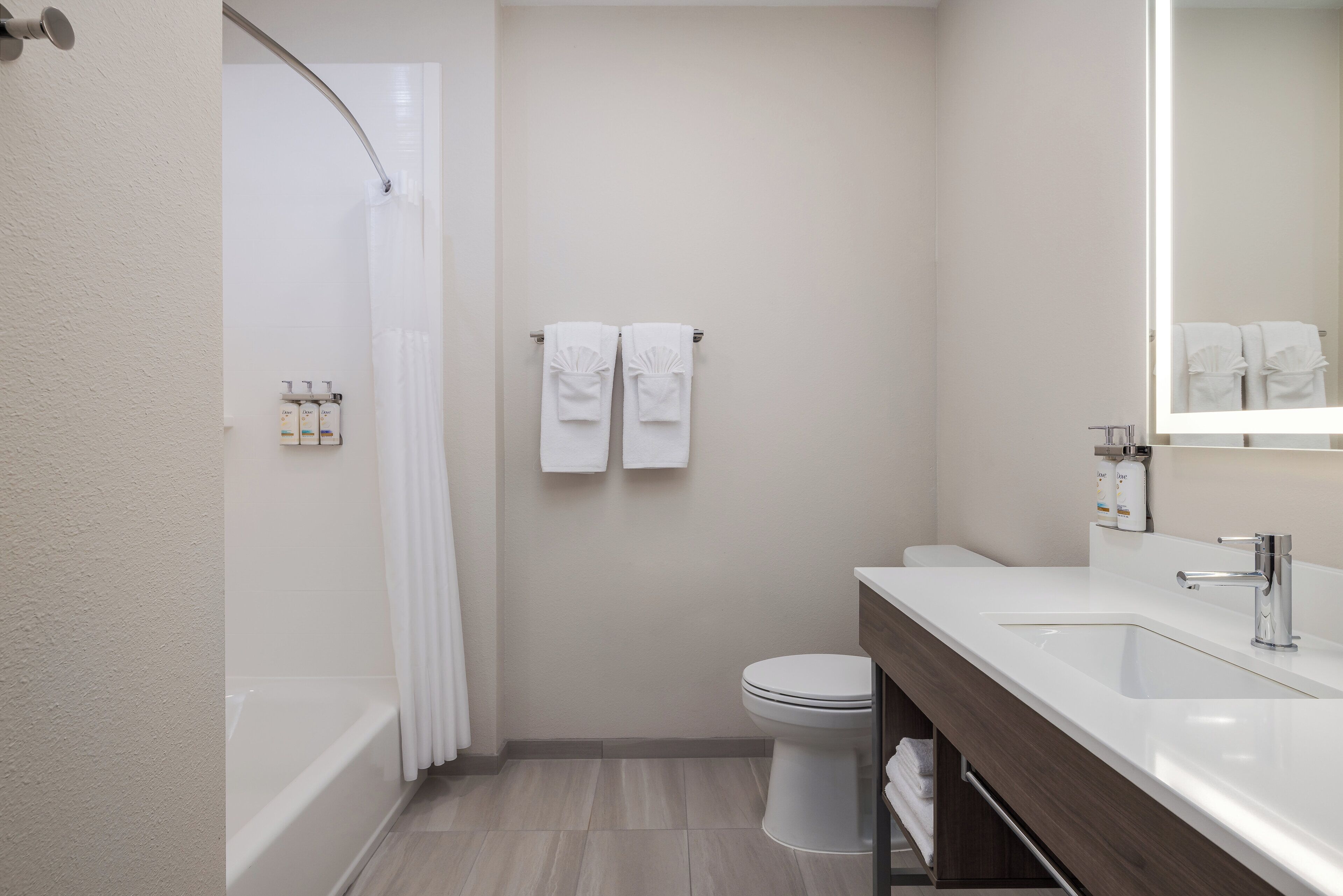 A modern bathroom with a bathtub, toilet, and sink.