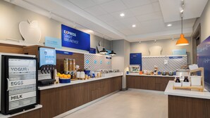 A modern breakfast area with labeled dispensers for yogurt, eggs, and milk, a bakery section, and a sign promoting express start breakfast. - Holiday Inn Express And Suites Nacogdoches Southwest by IHG (Nacogdoches)