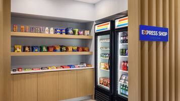 A snack and beverage display in a store with shelves stocked with various snacks and a refrigerated section with drinks.