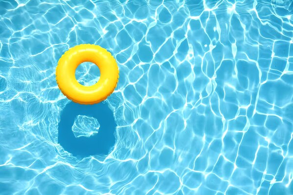 Ein klares, blaues Schwimmbecken mit einem gelben Schwimmreifen.