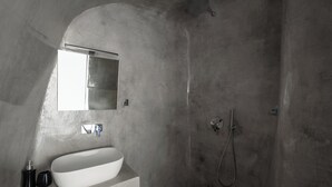 A bathroom with a white sink, a mirror, and a shower.