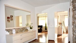Ein modernes Badezimmer mit einem großen Spiegel, einem Waschbecken und einer Duschkabine.