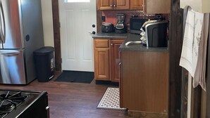 A kitchen with wooden cabinets, a stainless steel refrigerator, a microwave, and a gas stove.