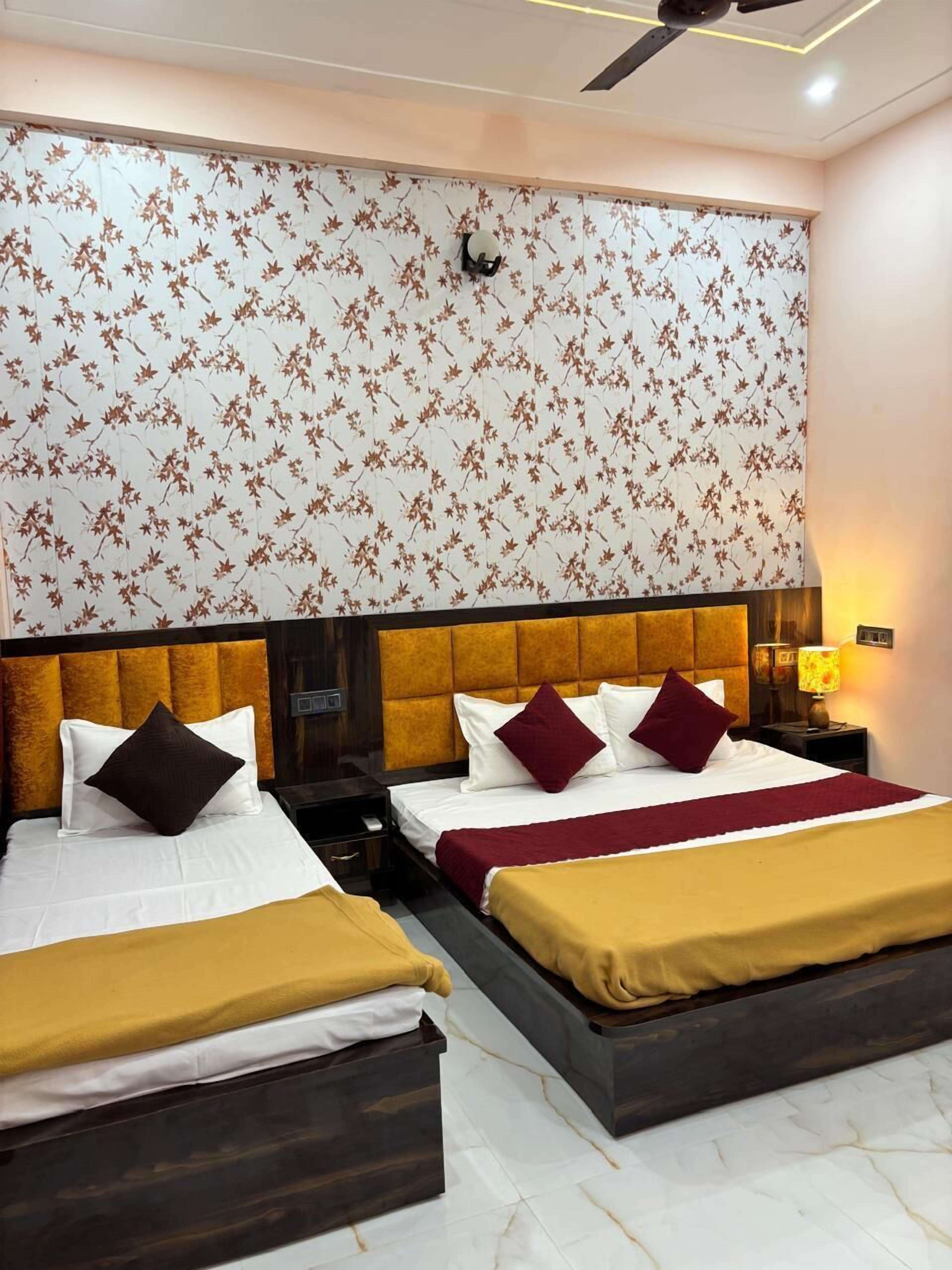 Una habitación de hotel con dos camas, cada una con cabecero, mesita de noche y lámpara.