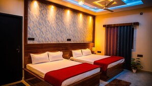 A hotel room with two beds, a ceiling fan, and a modern light fixture. - Krishnam Niwas Near Ram temple Ayodhya  (Faizabad)