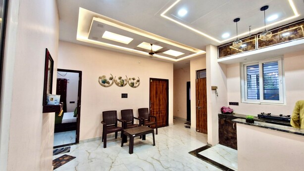 A modern kitchen with a marble floor, wooden cabinets, and a window with blinds. - Krishnam Niwas Near Ram temple Ayodhya  (Faizabad)