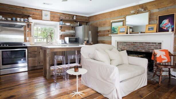 A modern kitchen with a white countertop, stainless steel appliances, and a wooden floor.