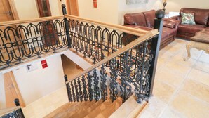 A staircase with ornate black metal railings, a wooden handrail, and a wooden floor. - Crea The Mission Hall (Antrim)