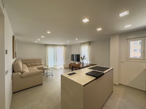 A modern apartment with a living area, kitchenette, and a dining space.