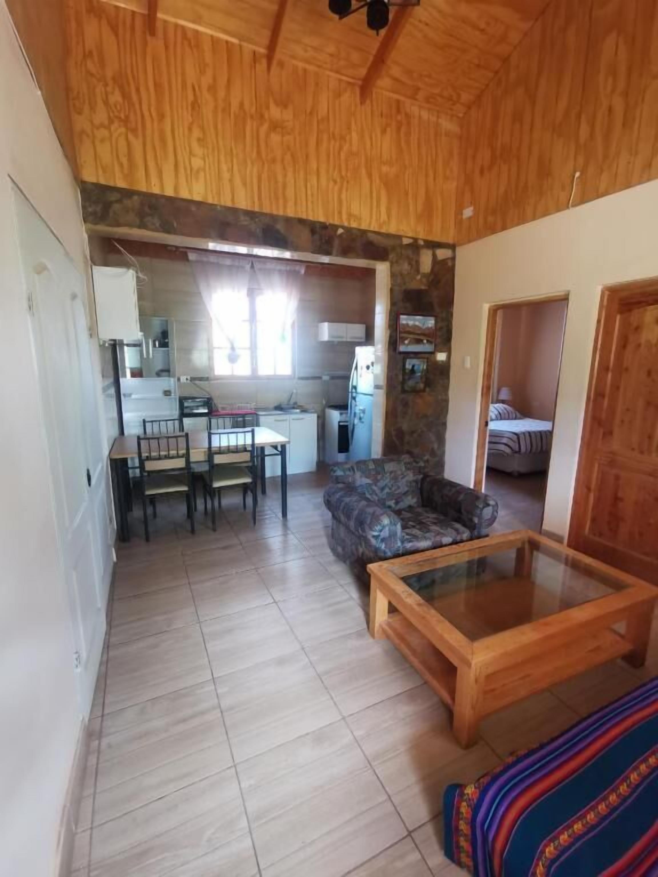 Un espacio habitable compacto con comedor, kitchenette y sofá.
