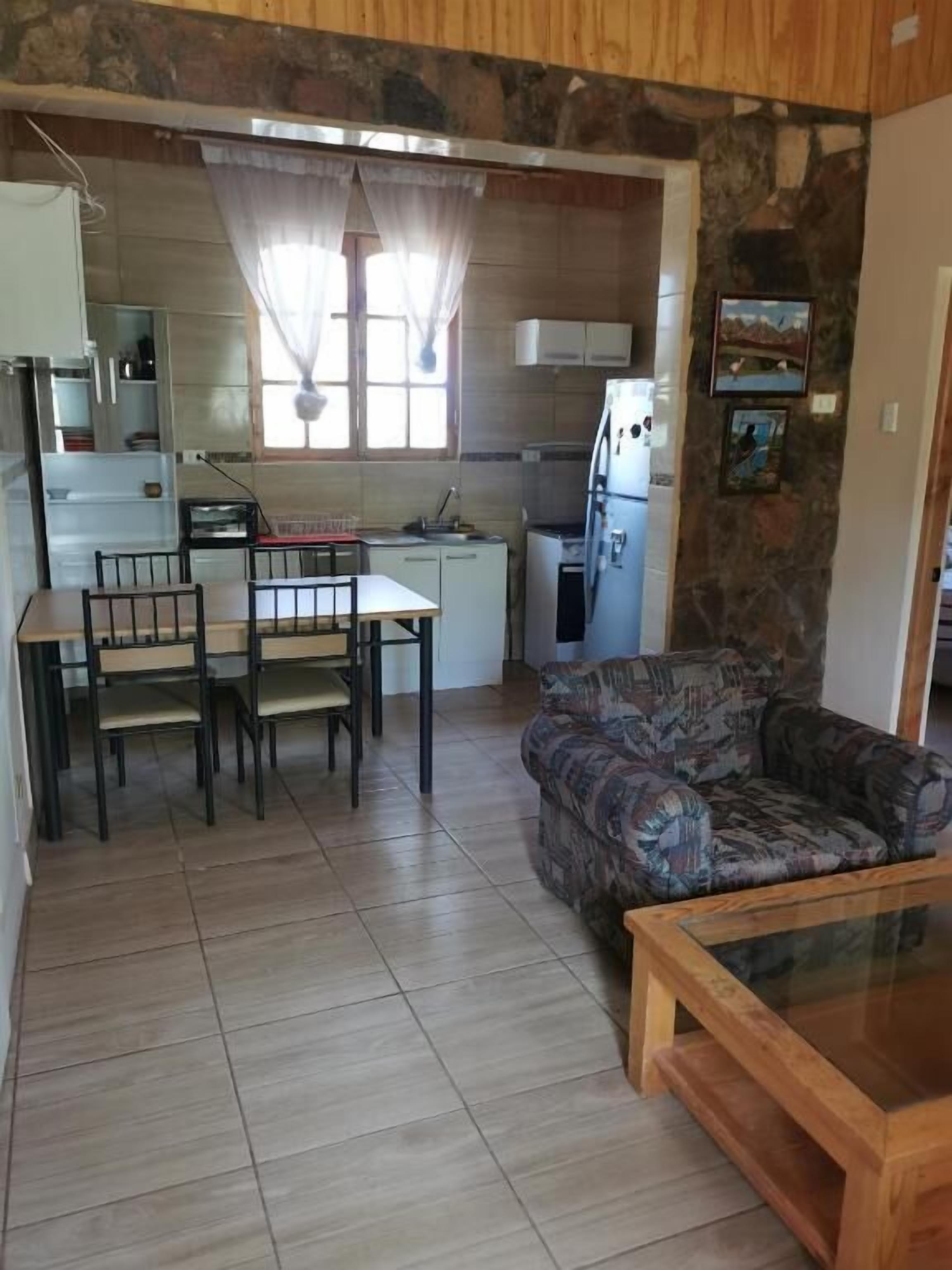 A compact living space with a dining area, kitchen, and seating area.