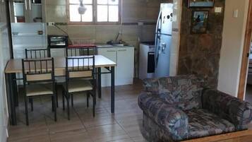 A compact living space with a dining area, kitchen, and seating area.