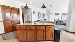 A spacious kitchen with wooden cabinets, a granite countertop, and pendant lighting. - Soaring Eagle Lodge #217 Beautiful upgraded Corner Unit Wraparound Balcony Ski-in/Ski-out Underground parking (Snowshoe)