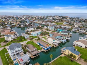 A coastal residential area with houses connected by waterways, featuring docks and waterfront properties. - A Little Palapa Paradise by Ryson Vacation Rentals (Galveston)