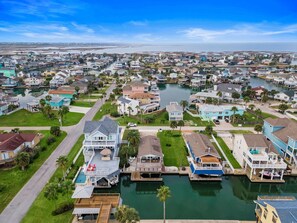 A residential area with houses, a marina, and a large body of water. - A Little Palapa Paradise by Ryson Vacation Rentals (Galveston)