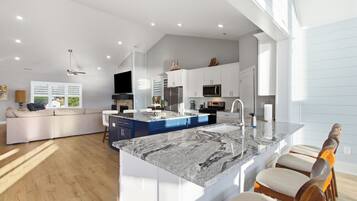 A spacious kitchen with a large island, modern appliances, and a dining area with bar stools.