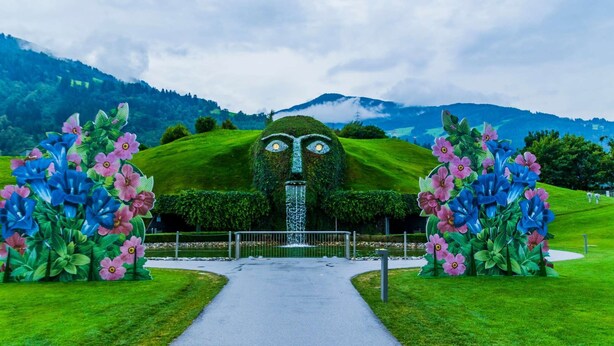 A pathway leading to a building with a unique facade featuring large floral designs and a waterfall. - Lovely Old Town Studio (Hall in Tirol)