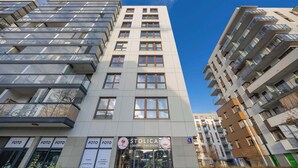 A modern building with multiple floors, large windows, and balconies.